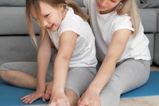 top of foot pain: mother and daughter stretching their foot